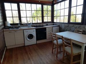 a kitchen with a washing machine and a table and chairs at El Molino de Candelario in Candelario