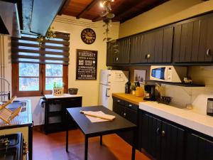 una cocina con armarios negros y una mesa. en Chalet de 3 chambres avec sauna et wifi a Arrens Marsous, en Arrens-Marsous