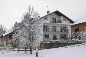 ein weißes Haus mit Schnee auf dem Boden in der Unterkunft Gacka idila in Otočac