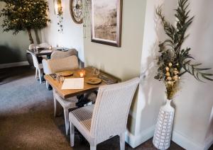 a dining room with a table and chairs and a vase at Harpur's of Melbourne in Melbourne