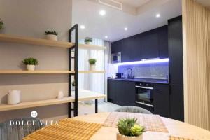 uma cozinha com armários pretos e uma mesa num quarto em Apartamento Milano Living Suites en Vila real em Villareal