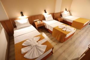 a hotel room with two beds and two tables at Luna Piena Hotel in Anamur