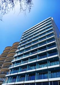 a tall glass building with a blue sky in the background at The Preluna Hotel in Sliema