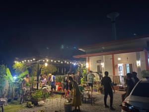 a group of people standing outside a house at night at เพียงภูโฮมสเตย์ in Sattahip