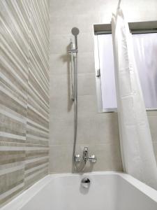 a bathroom with a tub and a shower with a window at Large apartment close to rocky beach MCRE1-1 in Sliema +21 photos