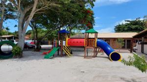 a playground with a slide in the sand at Pousada Algodão da Praia in Araruama