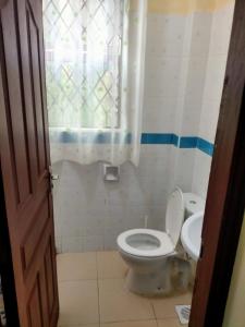 y baño con aseo y lavamanos. en FASTCARE Mj APARTMENTS And VILLAS, en Mombasa