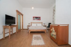 a living room with a bed and a tv at Family House in Lecce
