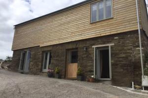 a brick building with a door on the side of it at Horsemans Barn in Kingsbridge