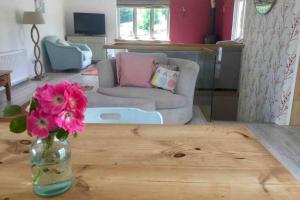 a living room with a vase of flowers on a table at Horsemans Barn in Kingsbridge