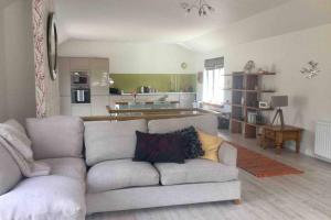 a living room with a couch and a kitchen at Horsemans Barn in Kingsbridge +14 photos