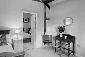 a bedroom with a bed and a desk and a mirror at Upper Heath Farm - Stable Cottage in Craven Arms