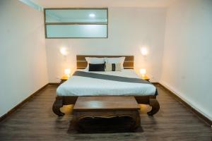 Grand Appart'Antaninarenina في أنتاناناريفو: غرفة نوم فيها سرير وطاولة فيها