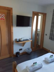 a room with two beds and a flat screen tv at The Ship Inn in Invergordon