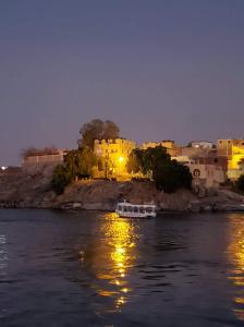 una barca in acqua con edifici sullo sfondo di Shipa's nubian house a Aswan