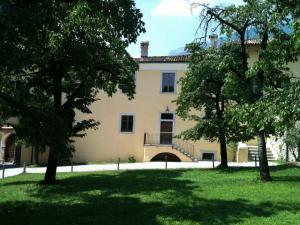 una grande casa con alberi di fronte di Relais Palazzo Lodron a Rovereto