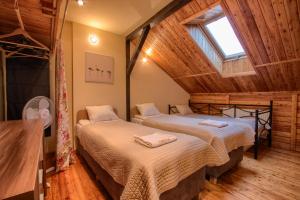 two beds in a room with a wooden ceiling at Marina Lester House in Rydzewo