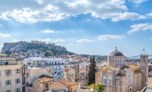 Blick auf eine Stadt mit einem Hügel im Hintergrund in der Unterkunft Athens Ivy Suites in Athen
