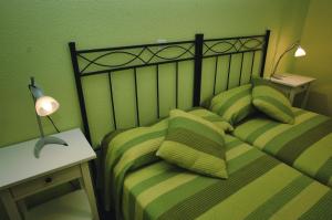 1 dormitorio con 1 cama con sábanas de rayas verdes en Perez del Molino - 5806, en Isla