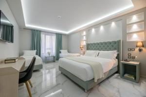 una camera d'albergo con due letti e una scrivania di Athens Starlight Hotel ad Atene Altre 37 foto