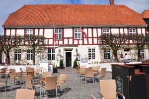 
a patio area with chairs, tables, and umbrellas at Hotel Ringkøbing in Ringkøbing
