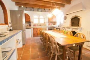 una grande cucina con tavolo e sedie in legno di Melegis 4-Bed Villa Sleeps 7 Pool & Garden a Melegis
