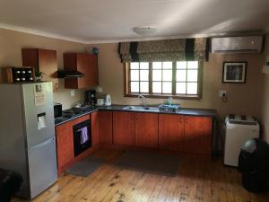 een keuken met houten kasten en een witte koelkast bij Luxury Treetop Lodge in Marloth Park +18 foto's