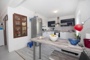 een keuken met een tafel en een koelkast bij Apartment Villa DD in Supetar