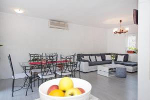 ein Wohnzimmer mit einer Obstschale auf dem Tisch in der Unterkunft Apartment Villa DD in Supetar