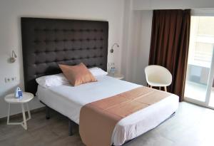 a hotel room with a bed, desk, and chair at Estudiotel Alicante in Alicante