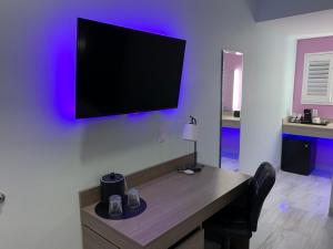 a room with a desk with a tv on the wall at Worthington of Logan in Logan