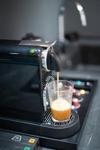 a drink is being poured into a cup on a microwave at Elysium Residence in Timişoara