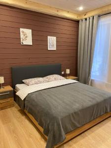sypialnia z łóżkiem i drewnianą ścianą w obiekcie Klub Otdyha Liubogorie w mieście Lyubytino