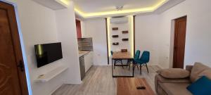 uma sala de estar com um sofá e uma mesa com cadeiras em JOANDI Apartments em Gevgelija