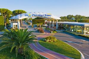 a post blue hotel with a palm tree in front of it at Estivo Premium Plus mobile homes on Camping Pra delle Torri in Caorle