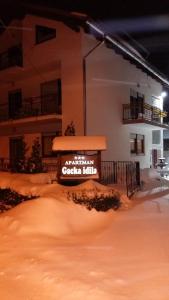 ein Schild im Schnee vor einem Gebäude in der Unterkunft Gacka idila in Otočac