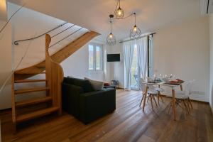 - un salon avec un escalier, une table et un canapé dans l'établissement Appartamento Batell, à Lezzeno