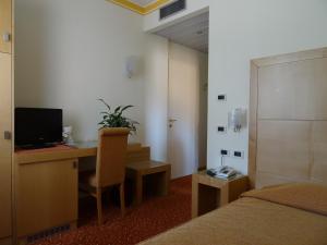 1 dormitorio con escritorio, 1 cama y ordenador en Hotel Roma, en Cividale del Friuli