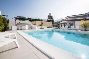 卡普多蘭多的住宿－Villa Concettina，一个带白色躺椅的游泳池和一个游泳池