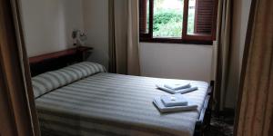 een slaapkamer met een bed met twee handdoeken erop bij Plaza Hotel in Capilla del Monte