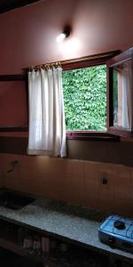 een raam met witte gordijnen in een kamer bij Plaza Hotel in Capilla del Monte