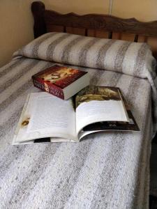two books sitting on top of a bed at Plaza Hotel in Capilla del Monte