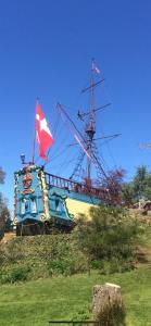 a boat sitting on top of a hill with a flag at Bondegårdsparken Farm Holiday in Kristiansand