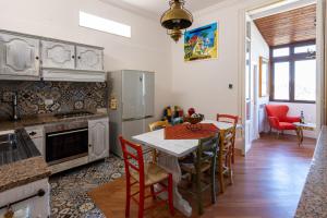 una cucina con tavolo e sedie di Le Rose di Nonna Maria, appartamento di lusso in centro città a Palermo
