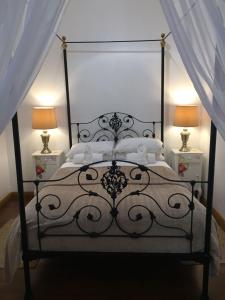 a bedroom with a black bed with two lamps at Skinkikofi Guest House in Paarl