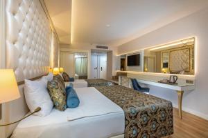 Haydarpasha Palace Hotel في أفسالار: غرفة الفندق بسرير كبير ومكتب