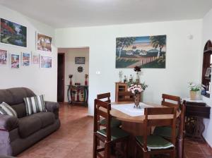 ein Wohnzimmer mit einem Tisch und einem Sofa in der Unterkunft Sítio entre Santo Antonio Pinhal e Campos do Jordão in Santo Antônio do Pinhal
