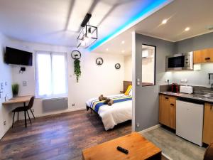 a bedroom with a bed and a kitchen with a table at Skyline Residence "Smart-Concept" in Limoges