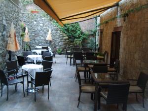 a restaurant with tables and chairs and a stone wall at Hostal Marboré in Bielsa