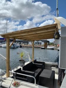 um barco com um deque de madeira sobre a água em Magnifique bateau maison em Ouistreham